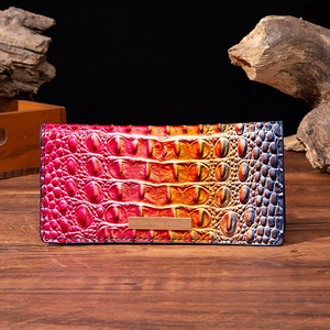 Macro detail of crocodile texture on pink blue gradient leather wallet with metal plate