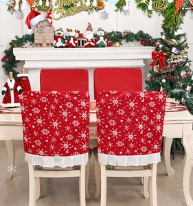 Détail de housse de chaise de Noël en tissu rouge avec flocons blancs et bord plissé