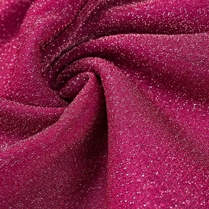 Macro shot of dark magenta fabric with sparkling glitter texture and spiral folds