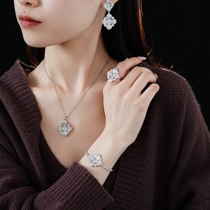 Parure de bijoux en argent avec boucles d'oreilles trèfle, collier, bague et bracelet sur mannequin