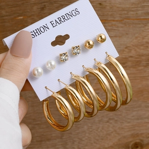 Détail d'un lot de 6 boucles d'oreilles dorées avec perles et strass sur présentoir