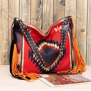 Close-up of bohemian woven tote bag with vibrant geometric patterns and orange fringe