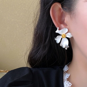 French vintage matte white flower earrings with gold center shown on model for women