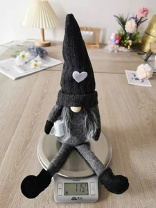 Knitted gnome Christmas decoration holding a coffee cup shown on a scale weighing 115.7g