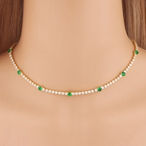 Gold tennis necklace with sparkling white zircons and vibrant green round gemstones