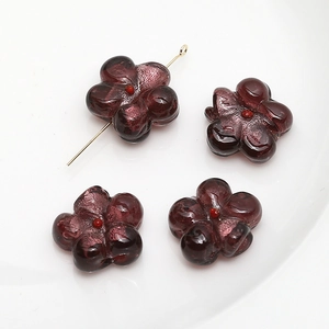 Macro shot of 4 dark purple glass flower beads with silver texture and golden T-pins
