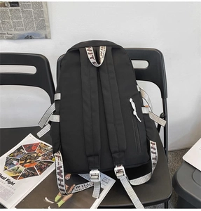 Detail of industrial black nylon backpack with striped woven straps on a vintage chair
