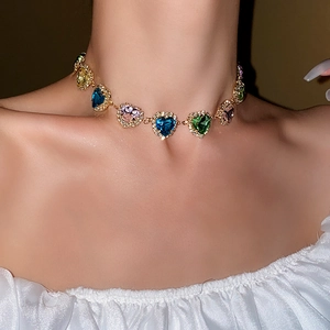 Close-up of a necklace featuring colorful heart-shaped gems with shimmering diamond borders