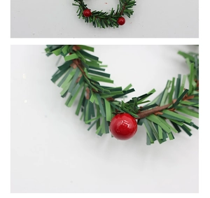 Detailweergave van kunstmatige dennennaalden en rode bessen op een kerstkrans