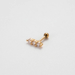 Detailed view of golden screw back ear stud with three sparkling zircon gemstones