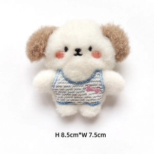 Detail shot of a white plush puppy pin with blue striped shirt, size 8.5cm by 7.5cm