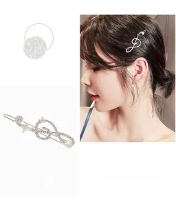 Detailed view of silver musical note hair clip with sparkling rhinestones and butterfly