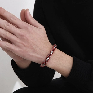 Detail of red and silver stainless steel link chain bracelet worn on a wrist