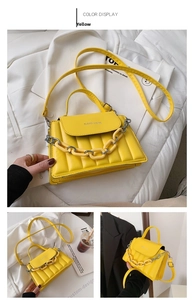 Detailed view of yellow quilted crossbody bag with chunky chain handle and flap closure