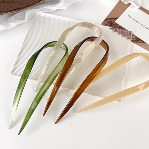 U-shaped hair pins in acetate green, pearl white and tortoiseshell on wave plate