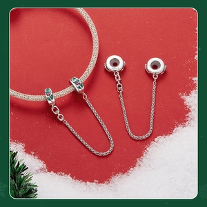 Macro shot of S925 sterling silver safety chain charm with festive red and green enamel