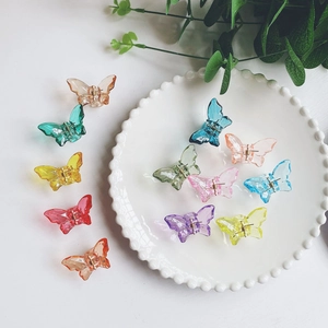 Colorful acrylic butterfly hair claws displayed on a decorative white ceramic plate