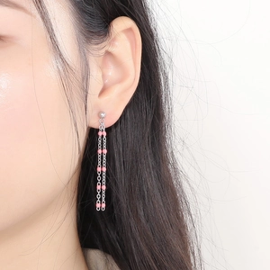 Minimalist silver chain tassel earrings with pink beads shown on model side profile