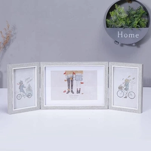 Detailed view of grey wood grain triple folding picture frame with decorative holiday art