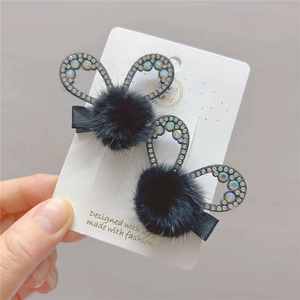 Close-up of hair clips with rhinestones and black faux fur rabbit ears on card