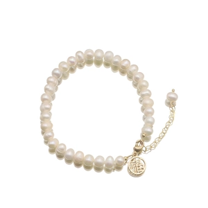 Elegant natural freshwater pearl bracelet with a golden Fu pendant on white background