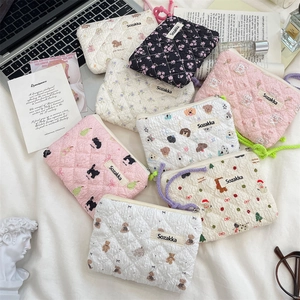 Flat lay of multiple floral quilted storage pouches with zippers and cute animal patterns