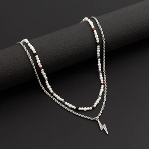 Detail of double-layer beaded necklace with lightning bolt pendant and crystals