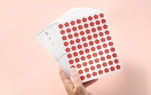 Close-up of red flower reward stickers held by hand for kids school and classroom use