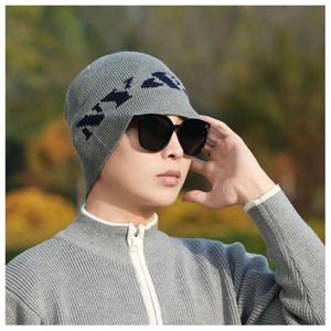 Close-up of grey knitted beanie with navy blue jacquard lettering and soft fabric texture