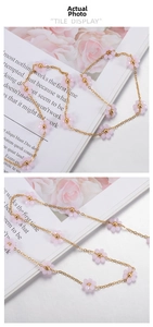 Detail of handmade gold chain with pink crystal flowers and intricate bead accents