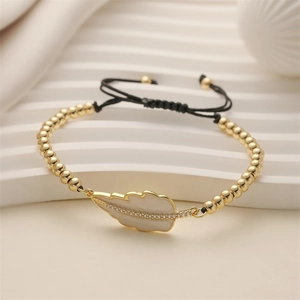 Close-up of gold beaded bracelet with white enamel leaf charm and zircon stones
