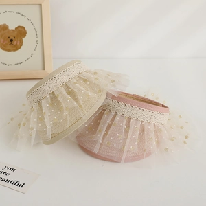 Close-up of kids straw sun visor with white lace trim and sequin mesh details