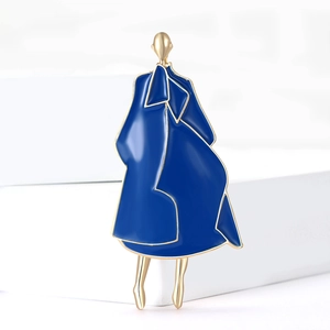 Detailed view of an elegant blue enamel fashion brooch displayed on a white stand