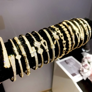 Detailed view of 18k gold plated bracelets with zircons on a black velvet display