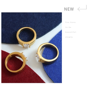 Detail view of 18K gold plated titanium rings featuring vertical stripes and square zircon