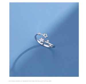 Macro shot of silver S925 star ring with white zircon stones on light blue background