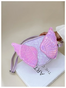 Detail of purple sequin girls crossbody bag with iridescent fairy wings on a book