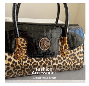 Detail of leopard print and black crocodile texture on bag with gold hardware