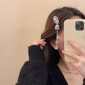 Detail of vintage silver hair clip with intricate white beads and tiered bell tassels