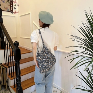 Floral pattern shoulder tote bag shown on a model with denim and a green beret
