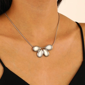 Gros plan d'un collier avec pendentif en lave liquide argentée et plaques superposées