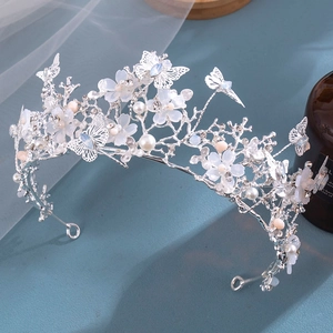 Detail of silver bridal crown with white flowers, pink pearls and rhinestones on veil