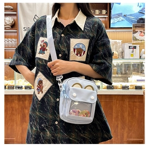 Close-up of light blue crossbody ita bag with cat ear design and transparent window layer