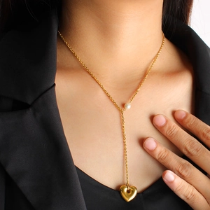 Elegant gold heart pendant necklace with pearl detail on a female model