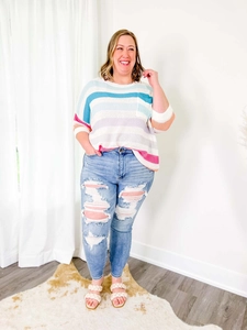 Détail d'un jean skinny bleu clair à taille haute avec de larges déchirures stylées