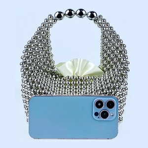 Detailed size comparison showing a silver beaded pillow bag next to a mobile phone