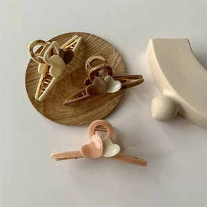 Elegant milk tea color heart hair claws in cream, brown, and pink on a stylish display