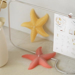 Artistic display of starfish scented candles in red and yellow with realistic wax texture