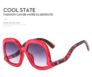 Detail of red irregular oversized frames with purple gradient lenses and leopard temples