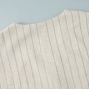Detailed close-up of striped linen vest neckline showing fabric texture and fine stitching